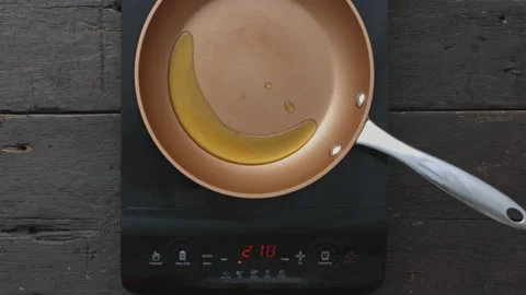 4k Time lapse of woman's hands frying and heating oil on digital induction stove Stock Footage 199616486