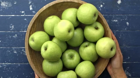 4k Time lapse of woman's hands choosing green apples out of wooden bowl until em Stock Footage 199616559