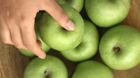 4k Time lapse of woman's hands placing green apples in a wooden bowl. Stock Footage 199616902