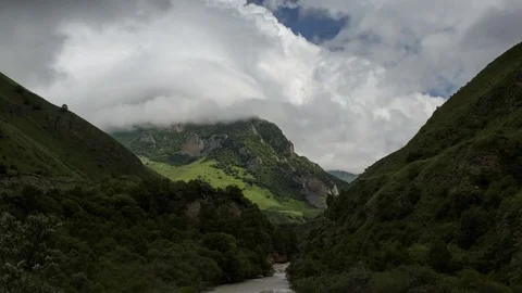 4K Timelaps Clouds slowly swim among the mountainous green scenic peaks Stock Footage 78084610