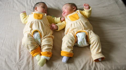 4k timelapse of 5 months old boy and girl twins babies lying, playing on the bed Stock Footage 64651113