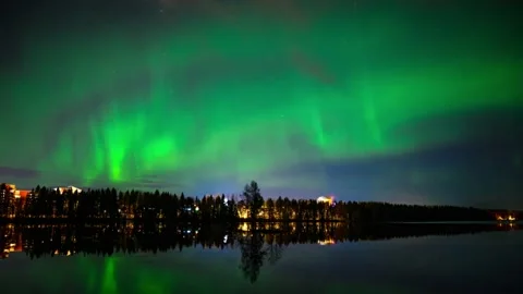 A 4k timelapse of Aurora Borealis dancing over a half-frozen lake with reflectio Stock Footage 144489835