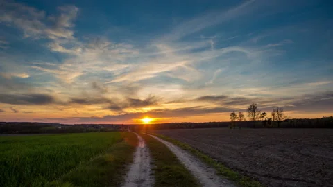 4k timelapse with beautiful, dramatic sunset sky over spring field and road Stock Footage 154083760