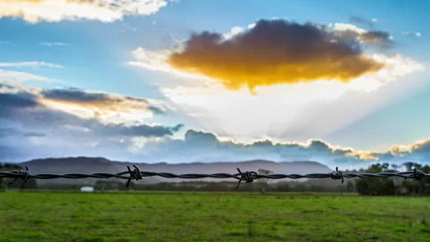 4K Timelapse Beautiful Sunset Through Barbed Fence Stock Footage 139334012