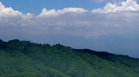 4K timelapse of clouds casting shadows on rolling green hills. Stock Footage 39792480