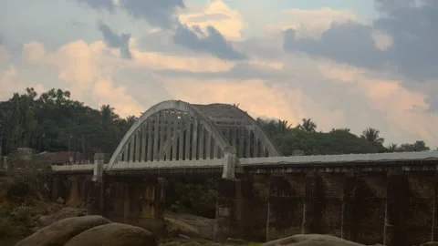 4K timelapse of clouds movement during sunset, over an arch bridge Stock Footage 147491944