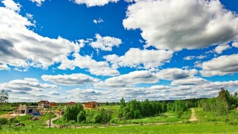 4k Timelapse clouds over the green field and small village. Stock Footage 72249847