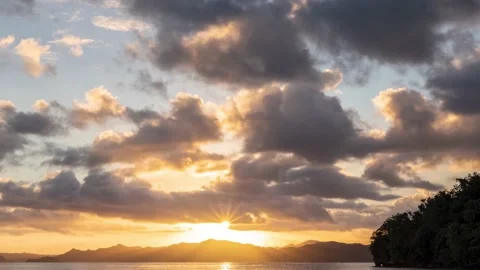 4K Timelapse, cloudy sunset over islands with sun rays shining through the cloud Stock Footage 130432907