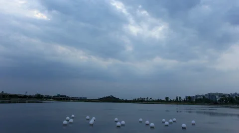 4k timelapse of dark clouds moving fast above a lake at dusk Stock Footage 49759793