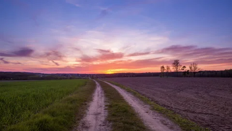 4k timelapse with dramatic sunset sky over spring field and road Stock Footage 154186500