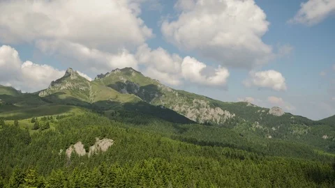 4k timelapse of dynamic light clouds on a blue sky over Ciucas Mountains. Stock Footage 77140369