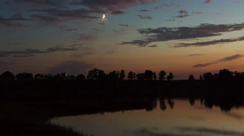 4k timelapse of evening sky with moon over lake Stock Footage 58931656