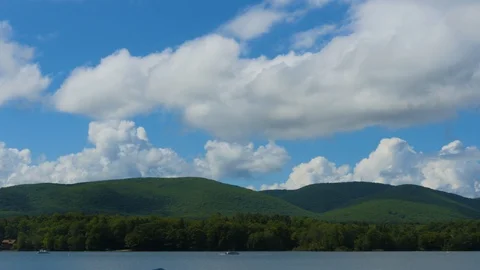 4K Timelapse - Fluffy Clouds Over Mountain Lake Stock Footage 128936777