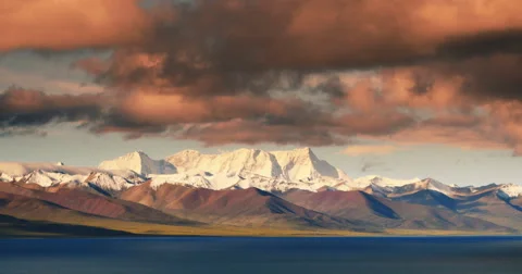 4k timelapse huge clouds mass over snow mountain,sunrise reflection lake namtso Stock Footage 45589849