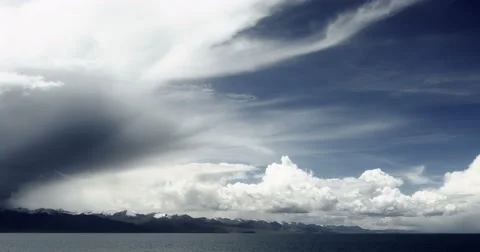 4k timelapse huge clouds mass rolling over lake namtso &amp; snow mountain in tibet Stock Footage 45616971