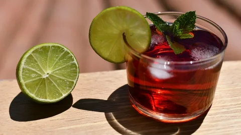 4k Timelapse of the ice melting in a red cocktail on a hot sunny day. Stock Footage 110124273