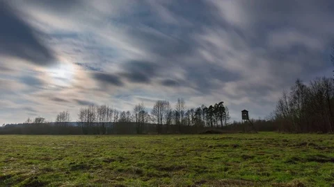 4k timelapse landscape with meadow and raised hide under cloudy sky Stock Footage 83564029