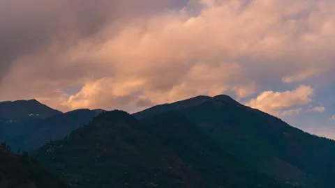 4K Timelapse of orange clouds moving above mountain range during sunset at Manal Stock Footage 340631969