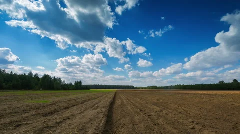 4k timelapse of plowed field under blue cloudy sky Stock Footage 58908561