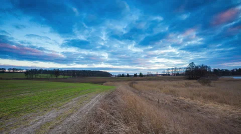 4k timelapse of spring field and grassland under cloudy evening sky Stock Footage 60693714
