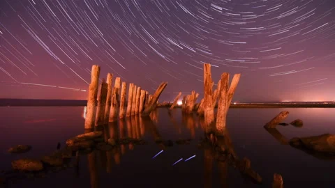 4k Timelapse star trail Night trails above ocean water Moving stars and clouds Stock Footage 220089004