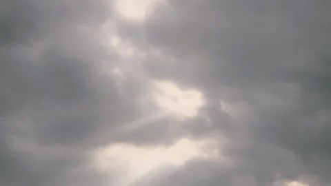 4k timelapse of sunrays peaking through stormy clouds 動画素材 343609813