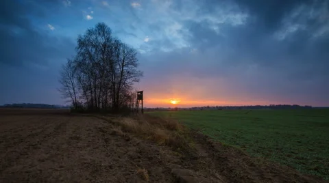 4k timelapse of sunrise over fields and raised hide and trees Stock Footage 60205611