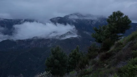 4K Timelapse of sunset clouds swirling around a San Gabriel Mountains snowy peak Stock Footage 270405153