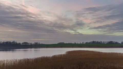 4k timelapse of sunset cloudy sky over autumnal lake Видео 60039722