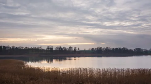 4k timelapse of sunset cloudy sky over autumnal lake 動画素材 60040254
