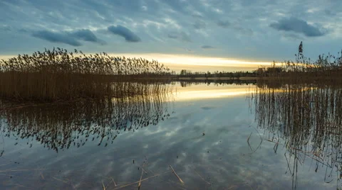 4k timelapse of sunset sky over lake and sky reflected in water Stock Footage 60695306