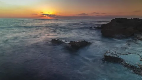 4K Timelapse view of the waves crashing on the rocks during sunset in the sea Stock Footage 312225957