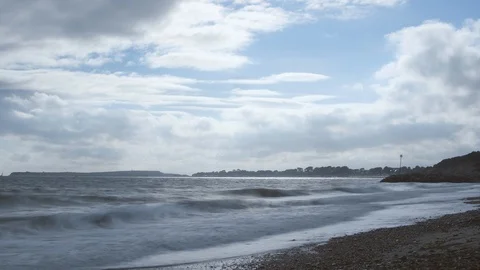 4K timelapse of waves on pebble beach in Dorset, cloudy, storm coming in Stockbeeldmateriaal 95810994
