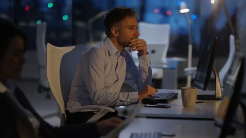 4K Tired businessman working late, working on computer at his desk Stock Footage