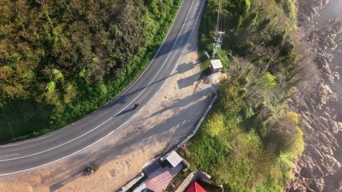 4K Top Down Drone Tracking Motorcycle Along Foggy Coastline Near Lighthouse Stock Footage 339267993