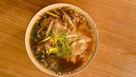 4K top down overhead view of Vietnamese rice noodle soup with green sliced .. Stockbeeldmateriaal 318128218