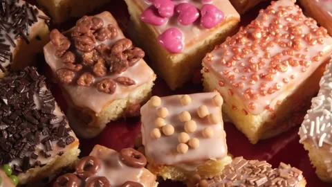 4K Top Down View of Assorted Decorated Sponge Cakes Rotating Right Stock Footage 333318614
