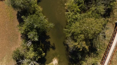 4k Top down view of stream in between farm land and trees Stock Footage 122786195