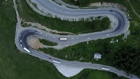 4k Top view of transport drive along curvy road in countryside irrl. Stock Footage 219630502
