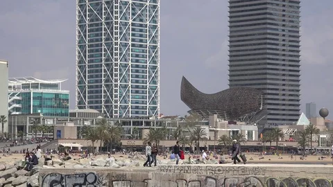 4K Tourist people relax on Barcelona beach golden fish sculpture landmark by day Stock Footage
