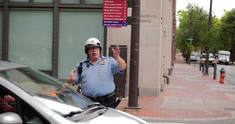 4K TRACKING SHOT OF COP GIVING DIRECTIONS TO DRIVER ON CITY STREET Stock Footage 132599865