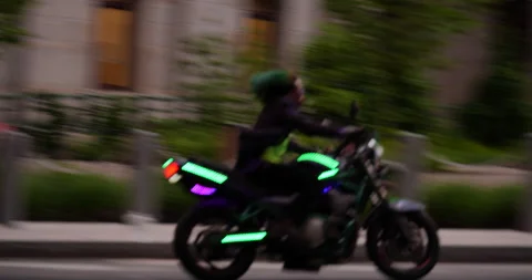 4K TRACKING SHOT OF MAN DRESSED LIKE JOKER ON MOTORCYCLE DURING PROTEST Stock Footage 131461048