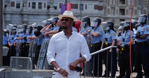 4K TRACKING SHOT OF PROTEST LEADER RALLYING IN FRONT OF COPS Stock Footage 131458406