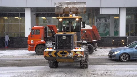 4k Tractor loading dump truck with snow Stock Footage 227122672