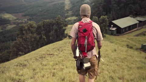 4k trekker walking home to log cabin after hiking in green mountain range with h 動画素材 199619072