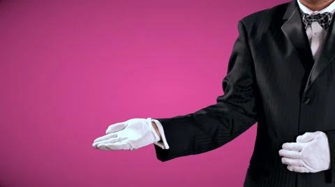 4K Tuxedo Man Gestures, Open Hand Reveal to Center Screen, Pink Background Stock Footage 66289912