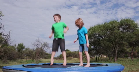 4K Two happy children jumping on trampoline Stock Footage