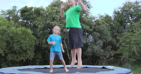 4K Two happy children jumping on trampoline Stock Footage 64711426