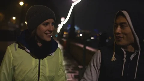4K Two joggers walking and talking at night in the city Video stock 72677963