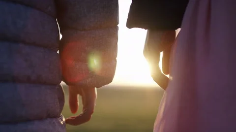 4K Two young children hold hands as they watch the sunset, in slow motion Видео 62187915